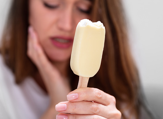 Woman with sensitive teeth after eating popsicle